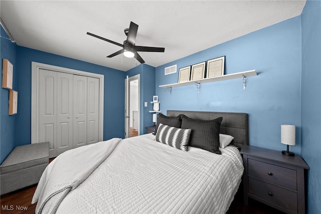 bedroom with dark hardwood / wood-style flooring, ceiling fan, and a closet