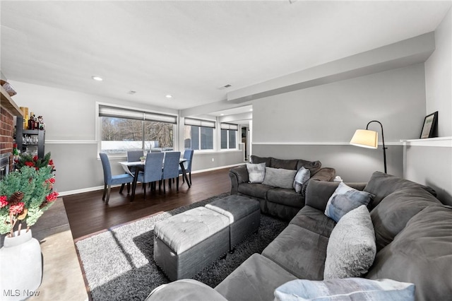 living room featuring a brick fireplace and hardwood / wood-style flooring