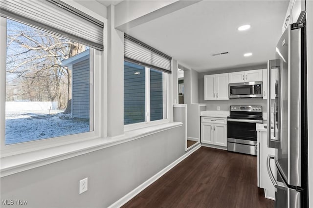 kitchen featuring stainless steel appliances, dark hardwood / wood-style floors, and white cabinets