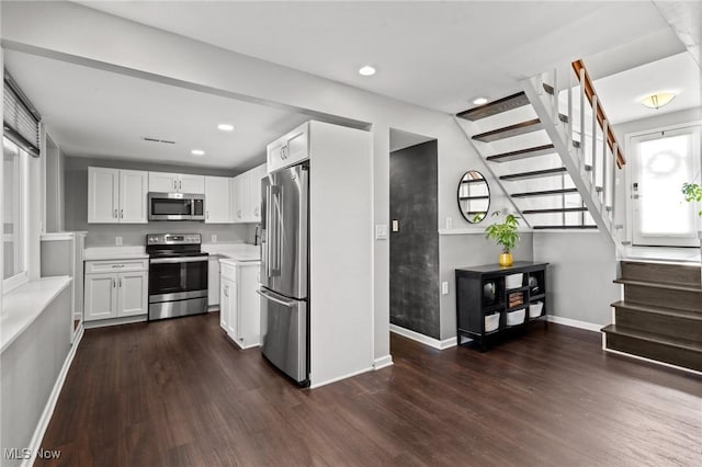 kitchen with stainless steel appliances, white cabinetry, and dark hardwood / wood-style flooring