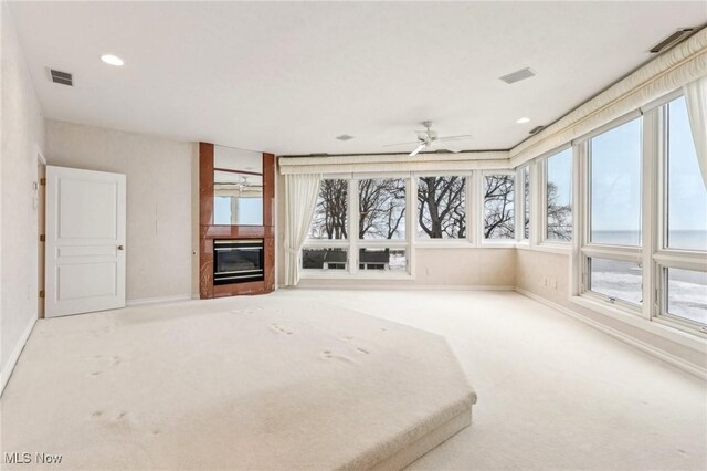 unfurnished bedroom featuring multiple windows, a large fireplace, and carpet flooring