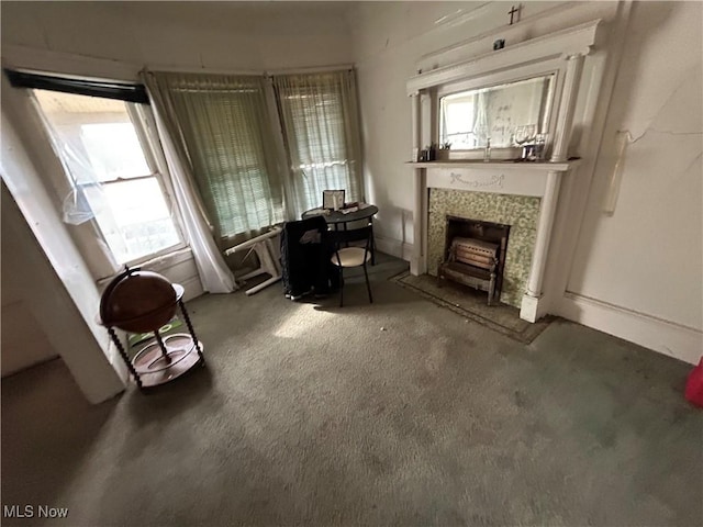 unfurnished room with plenty of natural light, a tile fireplace, and carpet