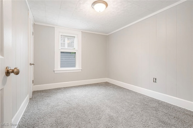 empty room featuring crown molding and carpet flooring