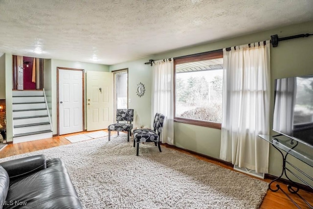 living room with a textured ceiling and light hardwood / wood-style flooring