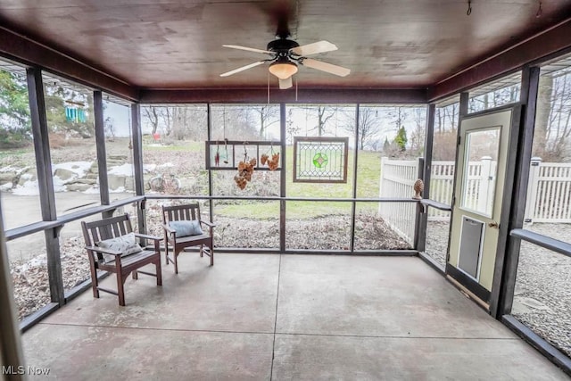 unfurnished sunroom featuring ceiling fan