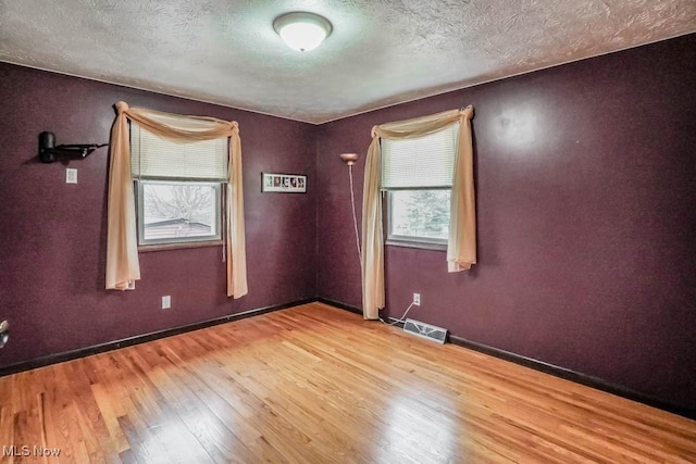 empty room featuring light hardwood / wood-style flooring and a textured ceiling