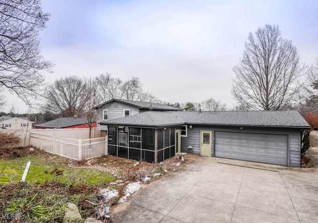 view of front facade with a garage and a sunroom