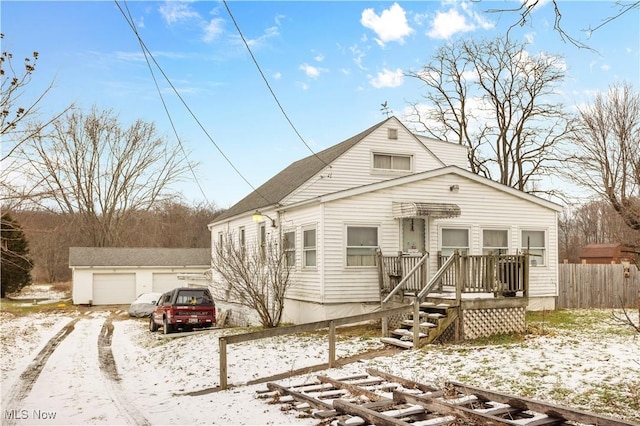 view of front of house featuring a garage and an outbuilding