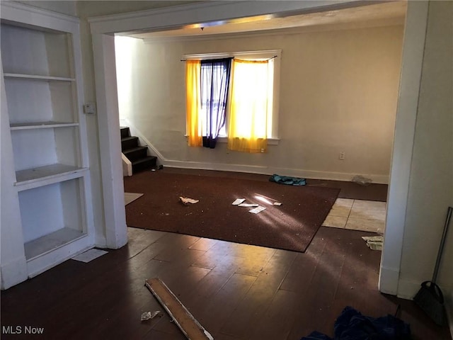 empty room with dark wood-type flooring and built in features