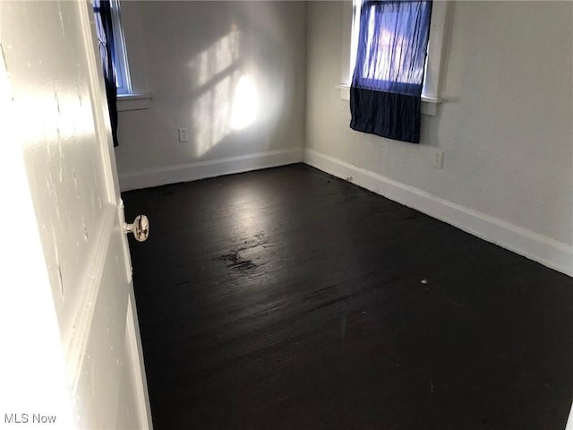 unfurnished room featuring dark hardwood / wood-style flooring