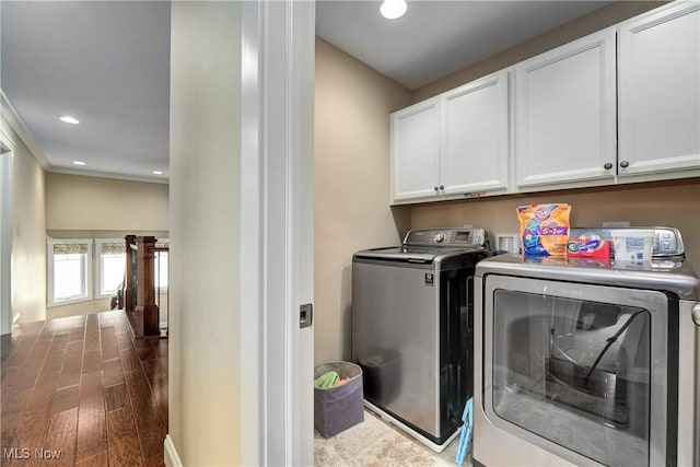 laundry area featuring crown molding, wood-type flooring, cabinets, and washing machine and clothes dryer