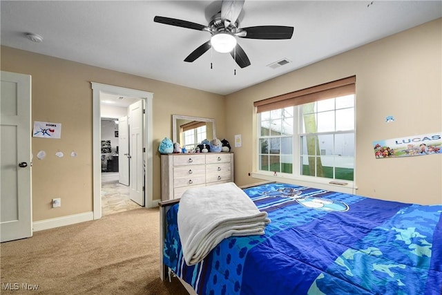 bedroom featuring connected bathroom, light colored carpet, and ceiling fan