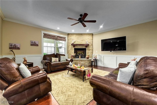 living room featuring crown molding, a stone fireplace, and hardwood / wood-style floors