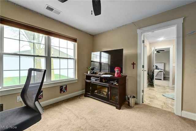 carpeted home office featuring ceiling fan