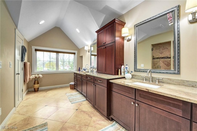 bathroom featuring lofted ceiling, vanity, tile patterned flooring, and a shower