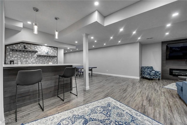 bar featuring hardwood / wood-style flooring, pendant lighting, and backsplash