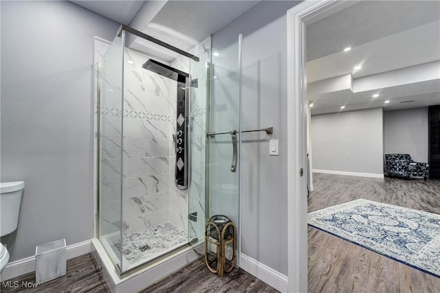 bathroom with wood-type flooring, an enclosed shower, and toilet