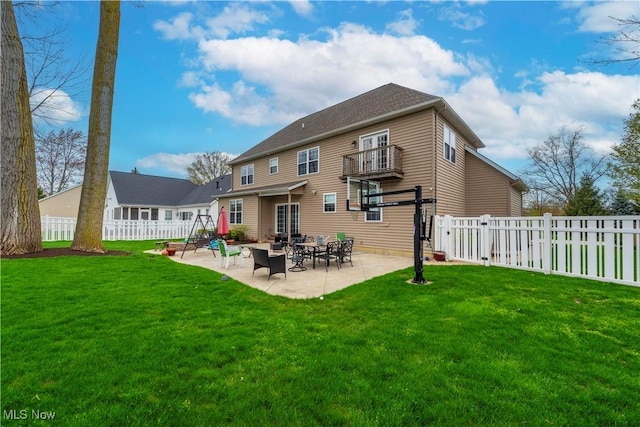 back of property with a lawn and a patio area