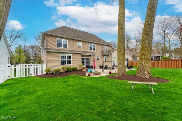 rear view of property with a yard, a patio, and a balcony