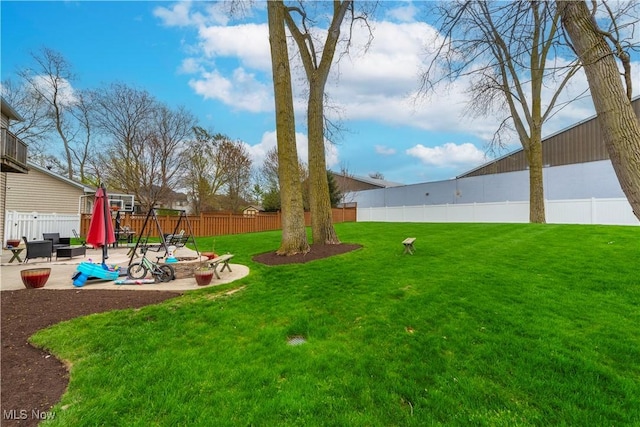 view of yard with a playground, a patio, and an outdoor fire pit