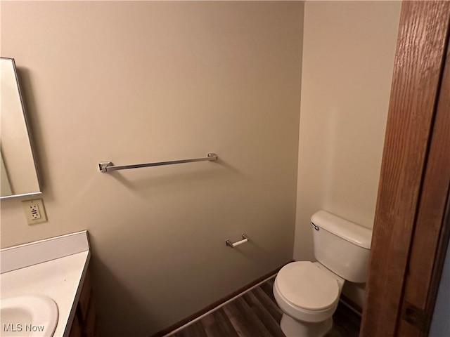 bathroom with wood-type flooring, toilet, and vanity