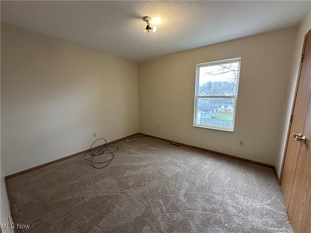 unfurnished room with carpet and a textured ceiling