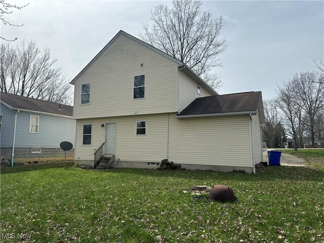 back of property with a yard and entry steps