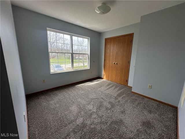 unfurnished bedroom with a closet, baseboards, and carpet