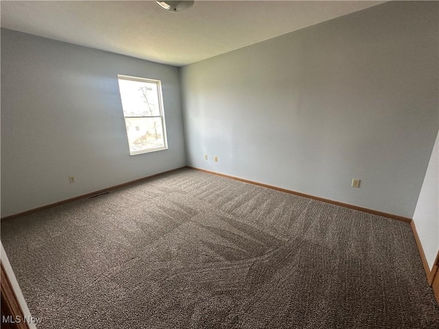 empty room with visible vents, baseboards, and carpet