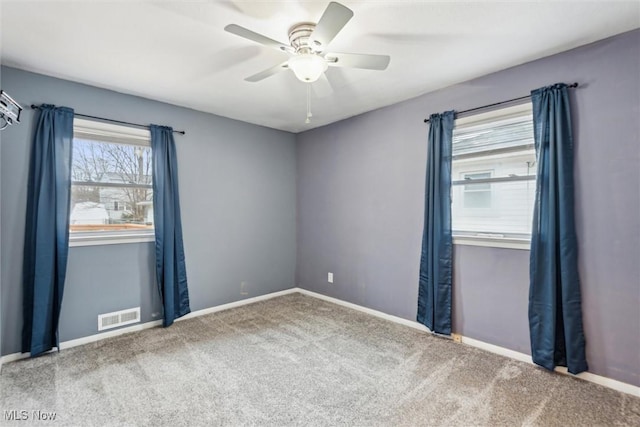 carpeted spare room featuring ceiling fan