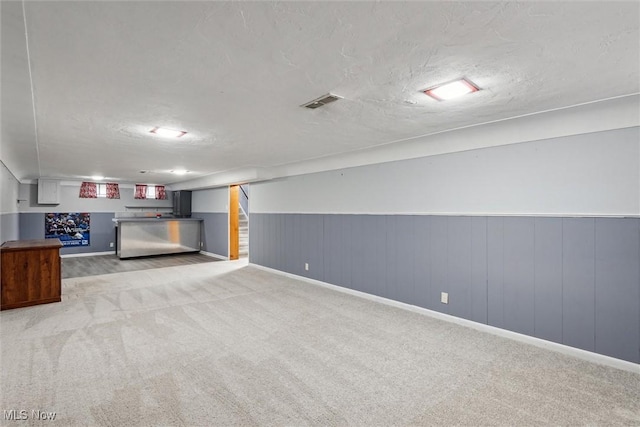 basement with light carpet and a textured ceiling