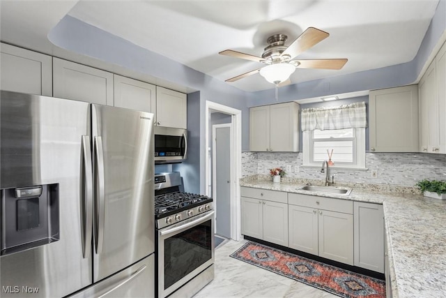 kitchen with stainless steel appliances, sink, gray cabinetry, and backsplash