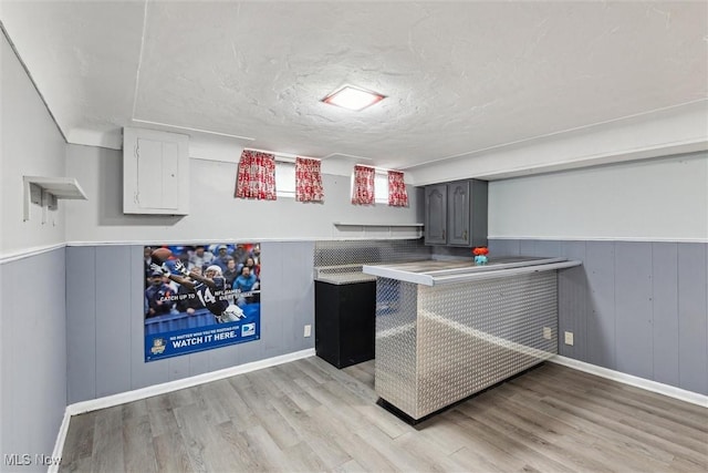 interior space with gray cabinetry, light hardwood / wood-style floors, and a textured ceiling