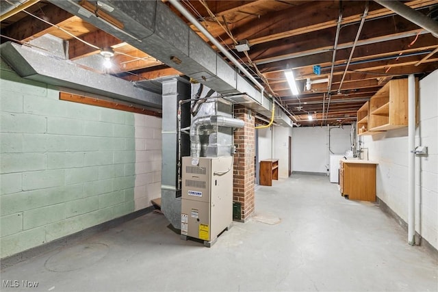 basement featuring heating unit and independent washer and dryer