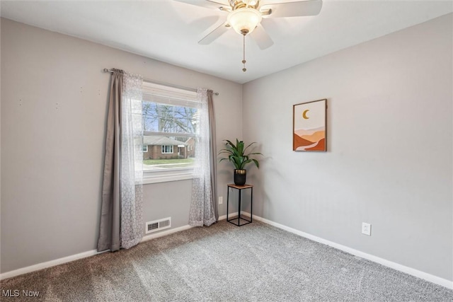 carpeted spare room featuring ceiling fan