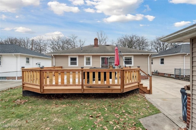 rear view of property featuring a yard and a deck