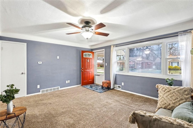 sitting room with ceiling fan, a textured ceiling, and carpet flooring