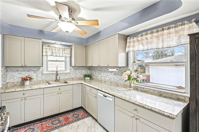 kitchen with light stone counters, sink, decorative backsplash, and dishwasher