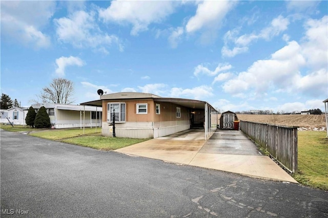 view of front of property featuring a front yard and a carport