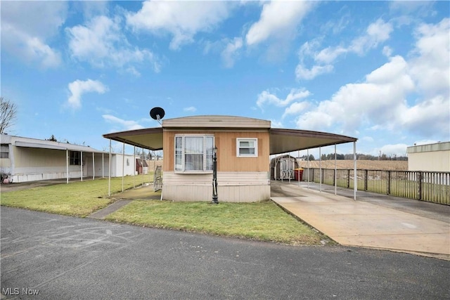 back of house featuring a carport and a yard