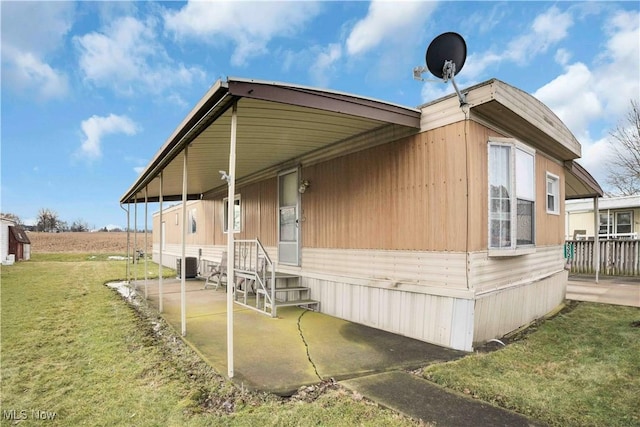 view of side of home featuring central AC and a lawn