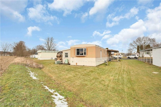 rear view of property featuring a carport and a lawn