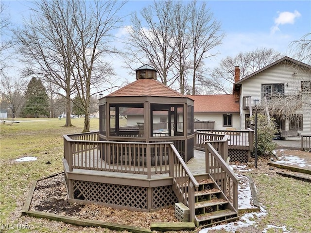 wooden terrace featuring a gazebo and a lawn