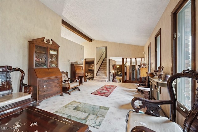 interior space with light carpet, lofted ceiling with beams, and a textured ceiling