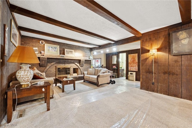 living room featuring a textured ceiling, a fireplace, beamed ceiling, and wood walls