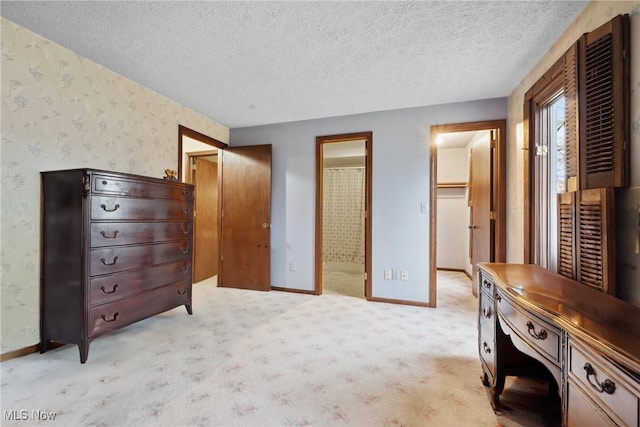 carpeted bedroom with a walk in closet, connected bathroom, a closet, and a textured ceiling