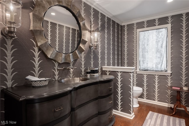 bathroom featuring vanity, hardwood / wood-style floors, crown molding, and toilet