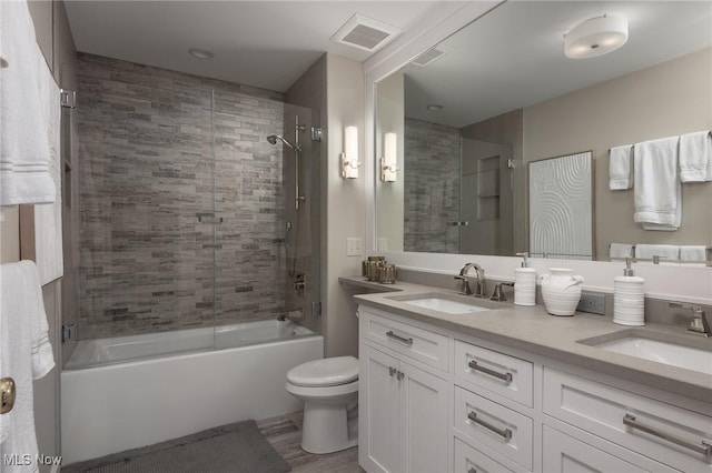 full bathroom featuring toilet, vanity, and shower / bath combination with glass door