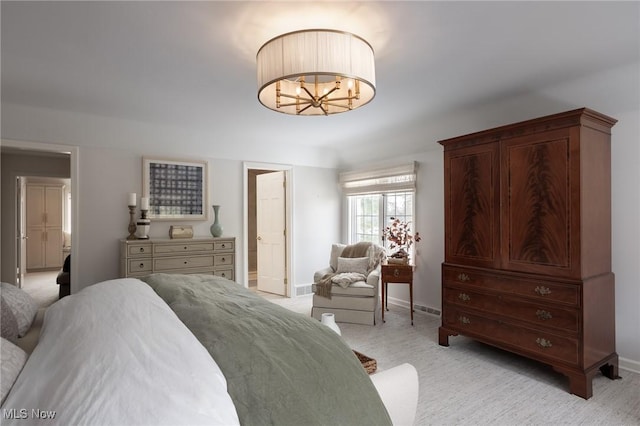 carpeted bedroom featuring an inviting chandelier