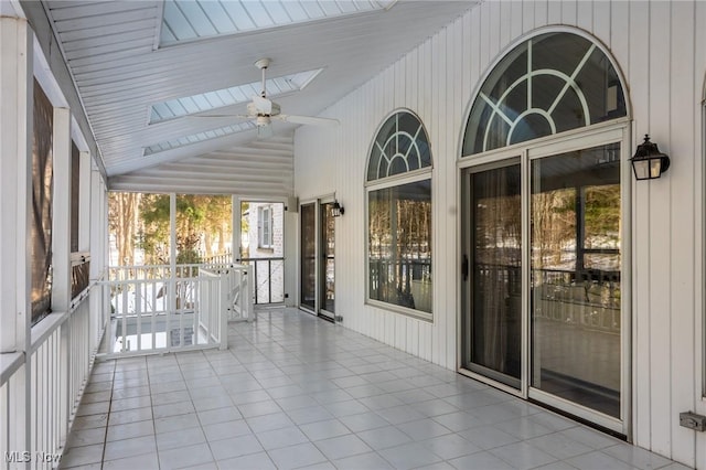 unfurnished sunroom with vaulted ceiling and ceiling fan